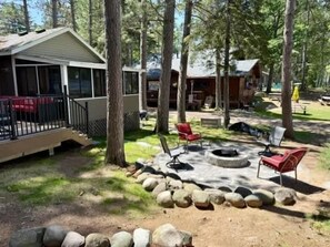 A cabin with a deck, a fire pit, and outdoor seating.