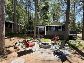 A cabin with a fire pit and outdoor seating. - Musky Hideout on Lost Land Lake (Hayward)