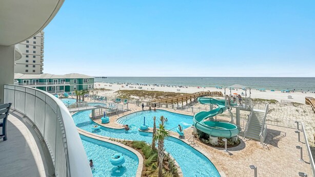 Ett poolområde på ett semesterhotell med flera vattenrutschkanor och utsikt över stranden.