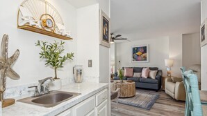 A modern kitchen with a marble countertop, a sink, and a decorative starfish.