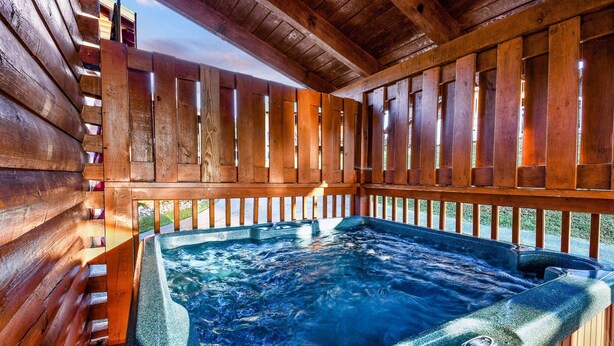 Un jacuzzi en un deck de madera con vistas al exterior.