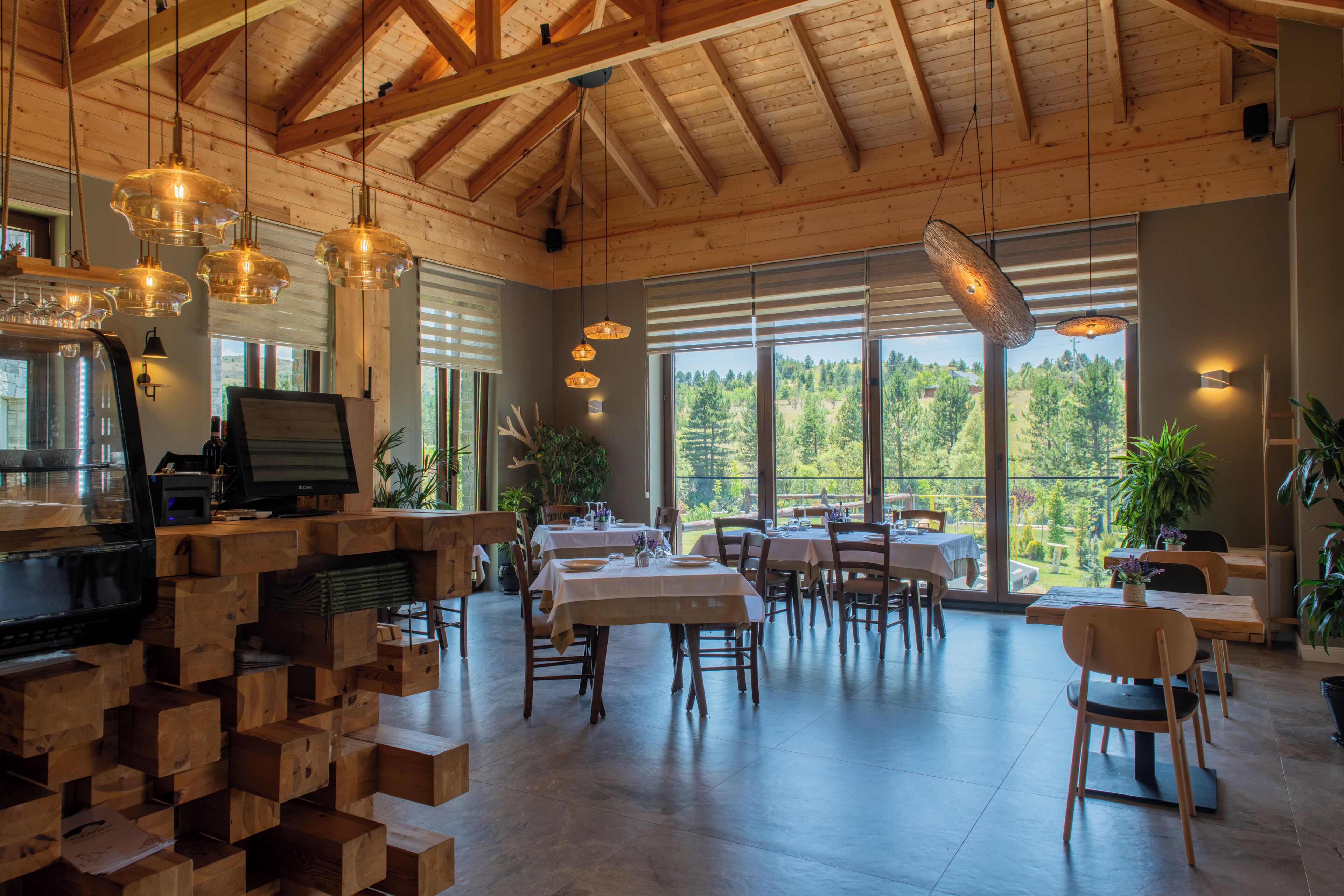 Un comedor amplio con luz natural, muebles de madera y vistas al exterior.