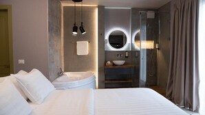 Une chambre d’hôtel moderne avec un grand lit, un lavabo intégré et une douche.