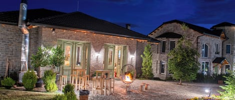 A stone building with a fire feature and outdoor seating.