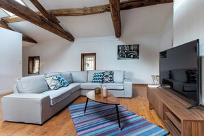 Relax in this stylish living room with a sofa, coffee table, and flat-screen TV.