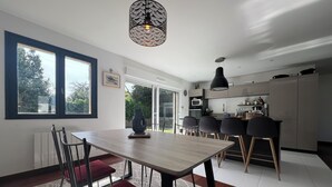 Una cocina moderna con zona de comedor, ventanas amplias y un tapete estampado.
