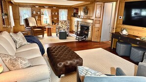 A cozy living room with a fireplace, comfortable seating, and a television.
