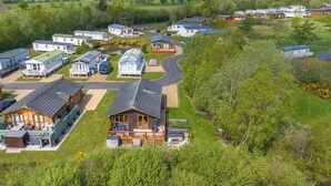 A residential area with multiple houses, a central road, and a body of water. - Fairway View - North East Escapes (Swarland)