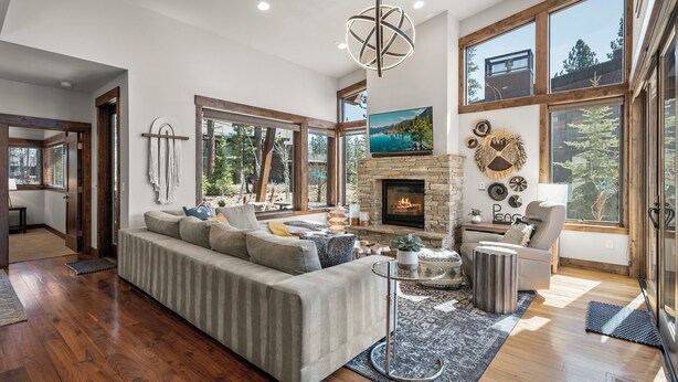 Amplia sala de estar con un sofá modular grande, una chimenea y ventanas amplias con vistas al exterior.