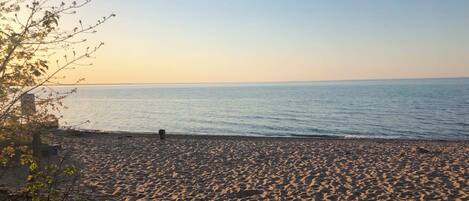 Una playa con arena y un mar tranquilo.