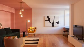 Un salon moderne comprenant un canapé, un fauteuil et un coin repas avec une table et des chaises.