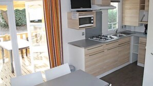 Eine kompakte Küche mit Mikrowelle, Herd und Fernseher.