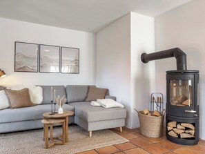 Una Smart TV, una chimenea, libros, un reproductor estéreo