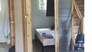 A room with a bed, a window, and a staircase. - ZEcamping 3* animé piscine chauffée locatif TV BBQ clim 36m2 6 pers (Argentonnay)