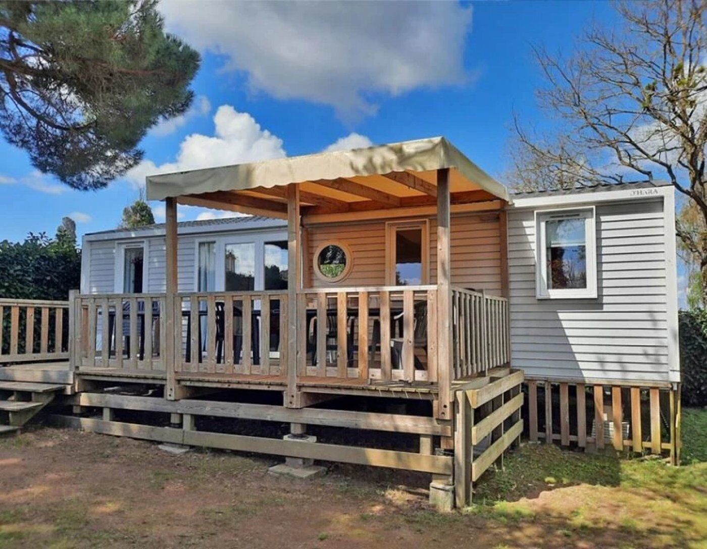 Ein Wohnmobil mit einer Holterrasse und einer überdachten Veranda.