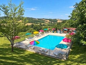 A rectangular swimming pool with a surrounding deck, lounge chairs, and umbrellas. - ZEcamping 3* piscine chalet TV clim 24m2 5 pers (Durfort)