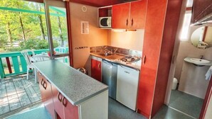 A compact kitchen with a gas stove, microwave, and sink.