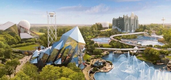 A theme park with futuristic structures, a large water body, and a castle-like building.