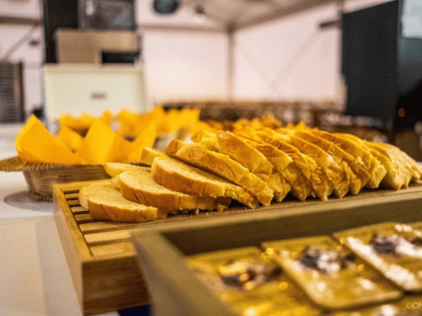 A buffet with sliced bread and fruit.