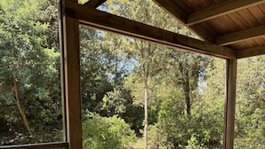 Une table en bois installée à l’extérieur, prévue pour les repas, et offrant une vue sur une zone boisée.