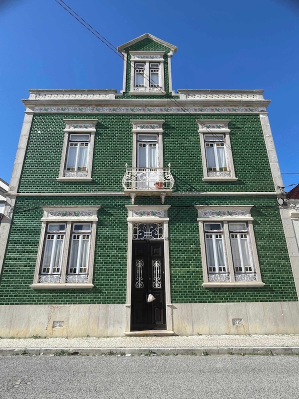 Un bâtiment écologique doté d’une entrée centrale, de nombreuses fenêtres et d’un balcon décoratif.