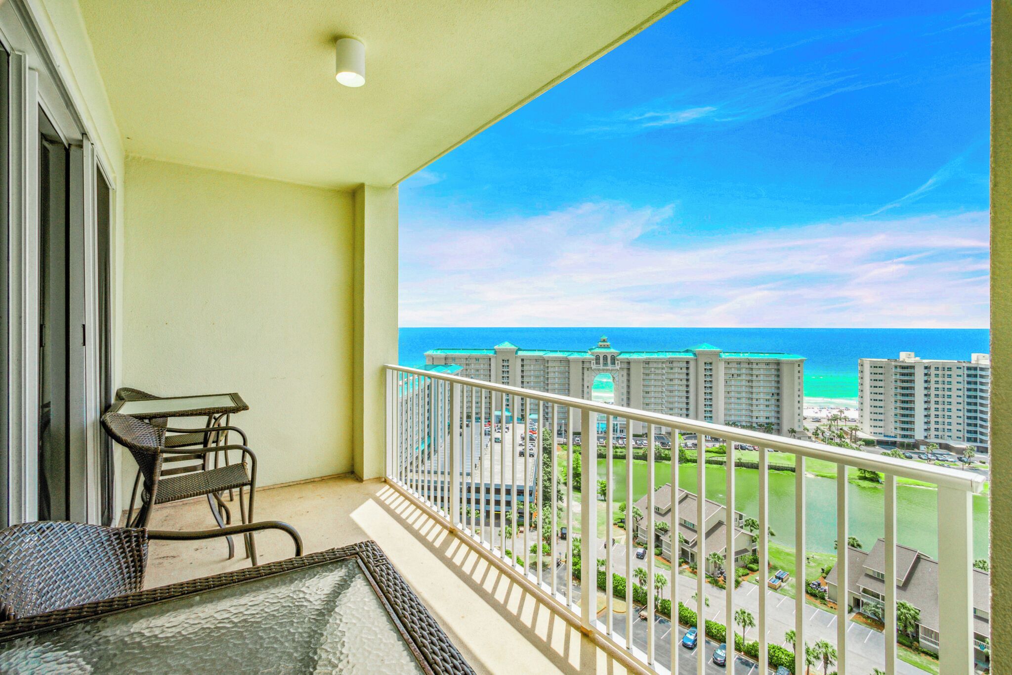 A balcony with a view of the ocean and high-rise buildings.