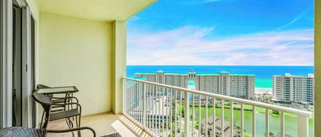 A balcony with a view of the ocean and high-rise buildings.