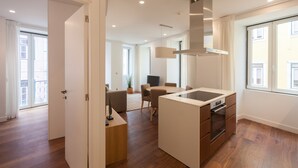 A modern kitchen with a central island, built-in oven, and pendant lighting. - FLH Glória 70 Apartment II (Lisboa ciudad)