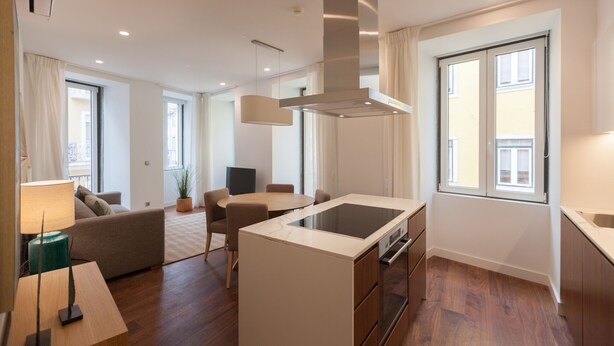 A modern kitchen with a central island, built-in oven, and stainless steel range hood. - FLH Glória 70 Apartment II (Lisboa ciudad)