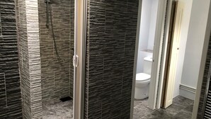 A modern bathroom with a shower, toilet, and sink. - Railway Inn (Buckhaven)