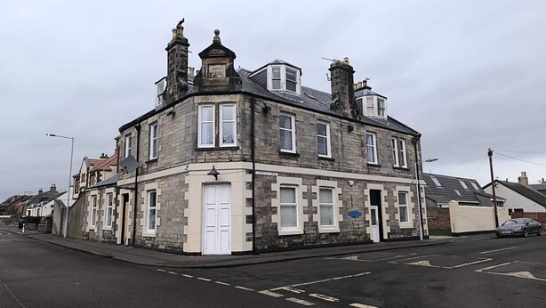 A corner building with multiple windows and a sign indicating 'Warren Street'. - Railway Inn (Buckhaven)