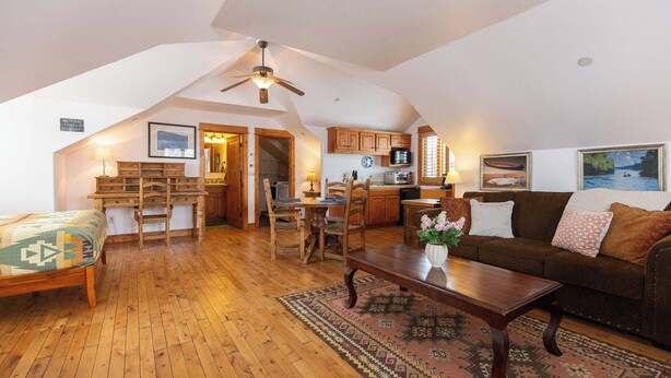 A loft-style living space with a kitchen, wooden furniture, and a ceiling fan. - Welcome to Hyalite Loft - Fully Furnished Loft Near Hyalite (Bozeman)
