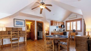 A spacious kitchen with wooden cabinets, a dining table with chairs, and a ceiling fan. - Welcome to Hyalite Loft - Fully Furnished Loft Near Hyalite (Bozeman)