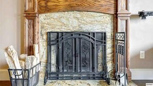 Una chimenea con repisa de piedra y diseño metálico detallado.