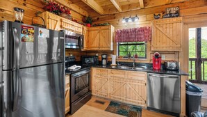 A rustic kitchen with wooden cabinets, stainless steel appliances, and a farmhouse aesthetic. - Sweet Bearoline-Great Views, Game Roon, Close to Dollywood (Sevierville)