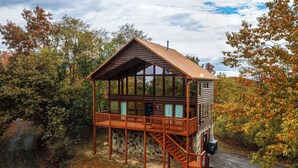 A cabin with a wooden exterior, a balcony, and a stone foundation. - Sweet Bearoline-Great Views, Game Roon, Close to Dollywood (Sevierville)
