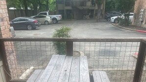 A wooden picnic table with benches on a balcony.