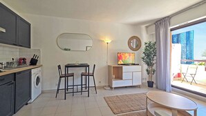 A compact living space with a kitchen, dining area, and a balcony with a view of a building. - LX146 - Studio cosy avec balcon & vue mer - Monaco (Beausoleil)