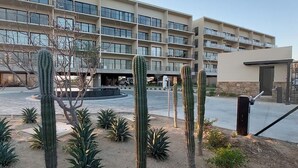 A multi-story hotel with a courtyard featuring cacti and a fountain.