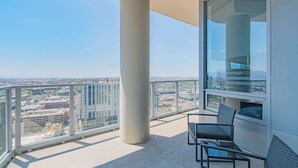 A balcony with a clear view of the cityscape, a glass partition, and a seating area with a table and chairs. - Upscale PHX Stay Pool,Gym,Balcony,WD,Parking (Phoenix)