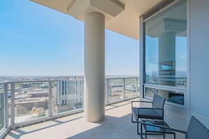 A balcony with a clear view of the cityscape, a glass partition, and a seating area with a table and chairs. - Upscale PHX Stay Pool,Gym,Balcony,WD,Parking (Phoenix)