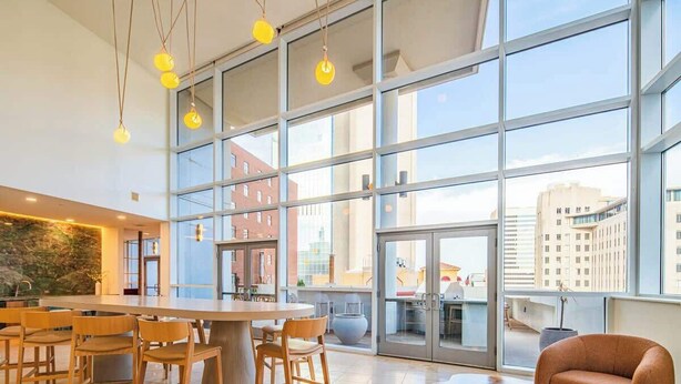 A spacious indoor area with large windows, a central wooden table, and several chairs. - Upscale PHX Stay Pool,Gym,Balcony,WD,Parking (Phoenix)