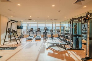 A gym with treadmills, elliptical machines, and weightlifting equipment.