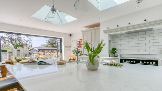 A modern kitchen with a large island, white cabinetry, and a skylight. - One Beach Road - sleeps 10 guests  in 5 bedrooms (Rhosneigr)