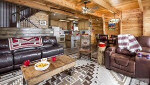 Ein gemütliches Blockhaus-Interieur mit Ledersofa, Couchtisch und Essbereich.