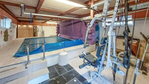 An indoor swimming pool with a diving board, a water filtration system, and a staircase leading to a door. - Gorgeous apartment in åsljunga (Åsljunga)