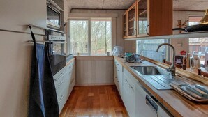 A compact kitchen with a built-in oven, a sink, and a window providing natural light. - Cozy apartment in åsljunga with sauna (Åsljunga)