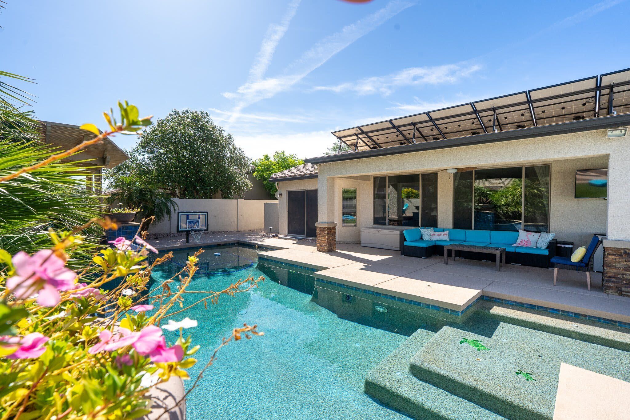 A modern outdoor pool area with a built-in seating area and a pergola.
