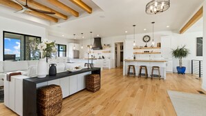 A spacious kitchen with a central island, wooden beams, and modern lighting. - Bridle Ridge Retreat | Modern Comfort, Open Views (Severance)