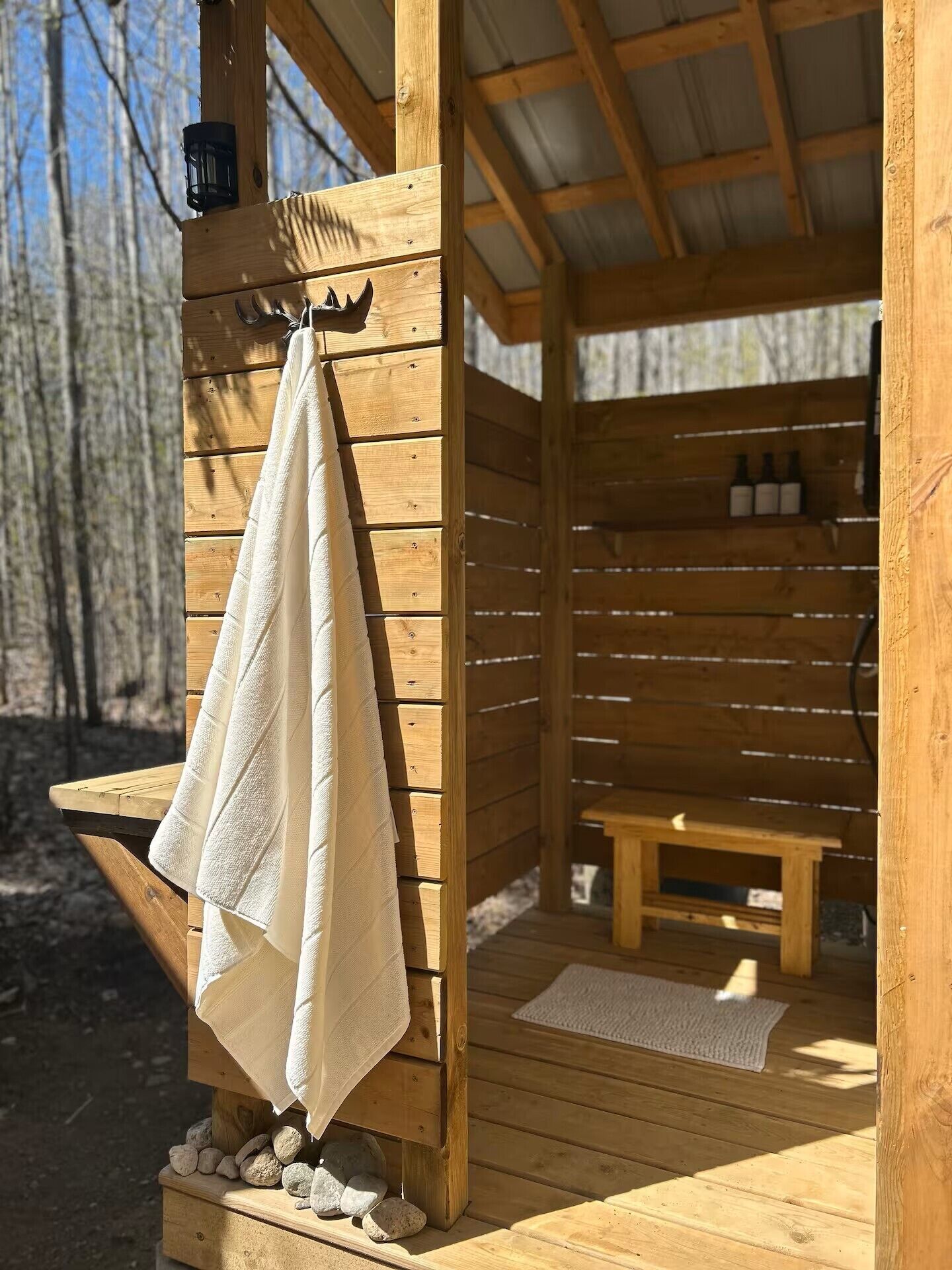 Una cabaña de madera con un banco y una toalla colgada de un perchero.